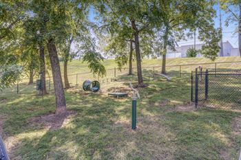 a dog park with trees and a dog kennel